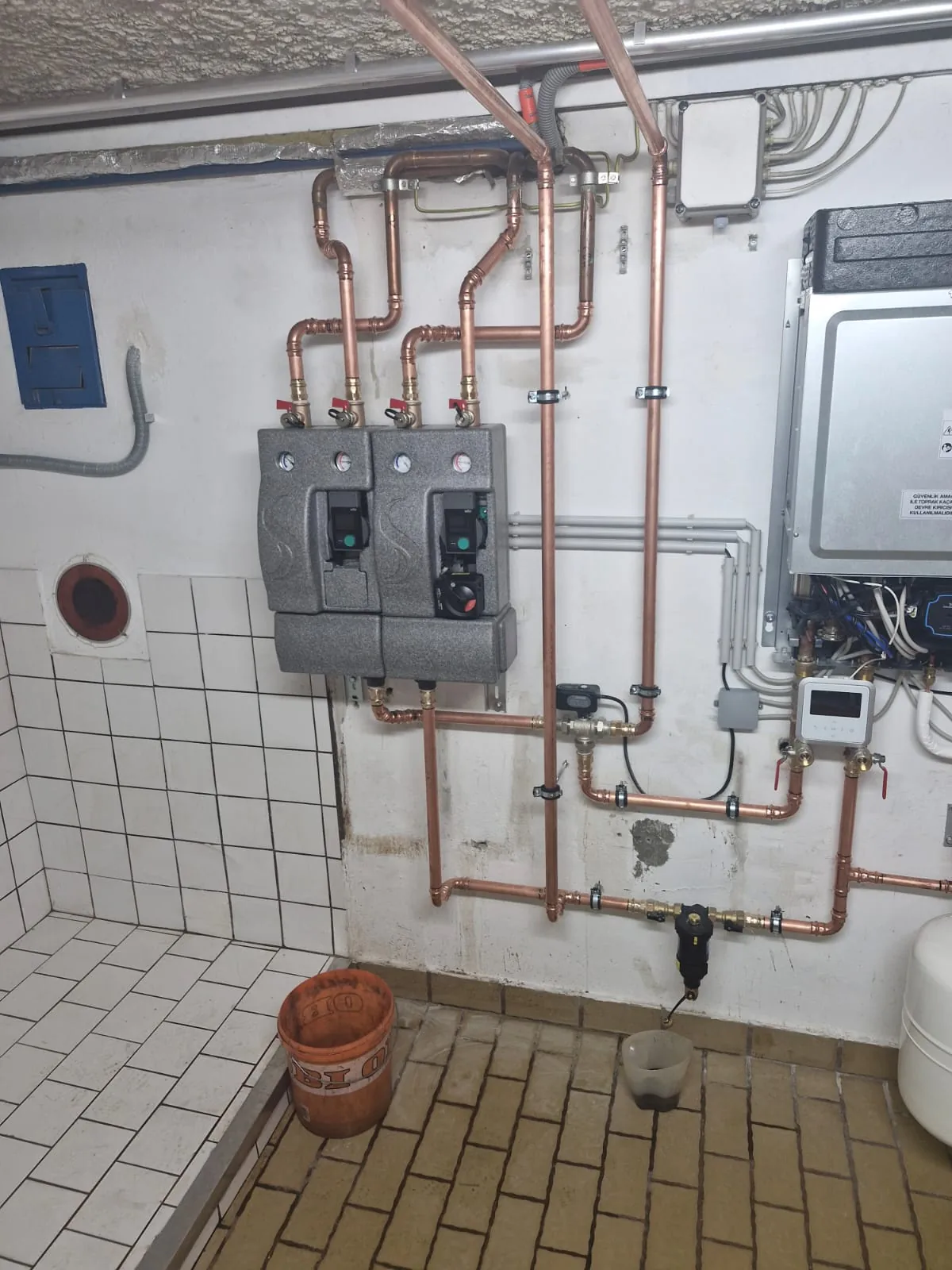 Technikraum mit Kupferrohren und hydraulischer Pumpengruppe