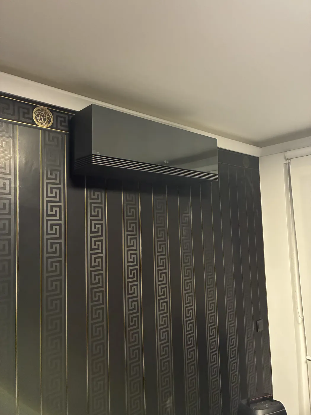 Schwarze LG ARTCOOL AI Air Klimaanlage an einer dunklen Designtapete in einer Wiener Wohnung