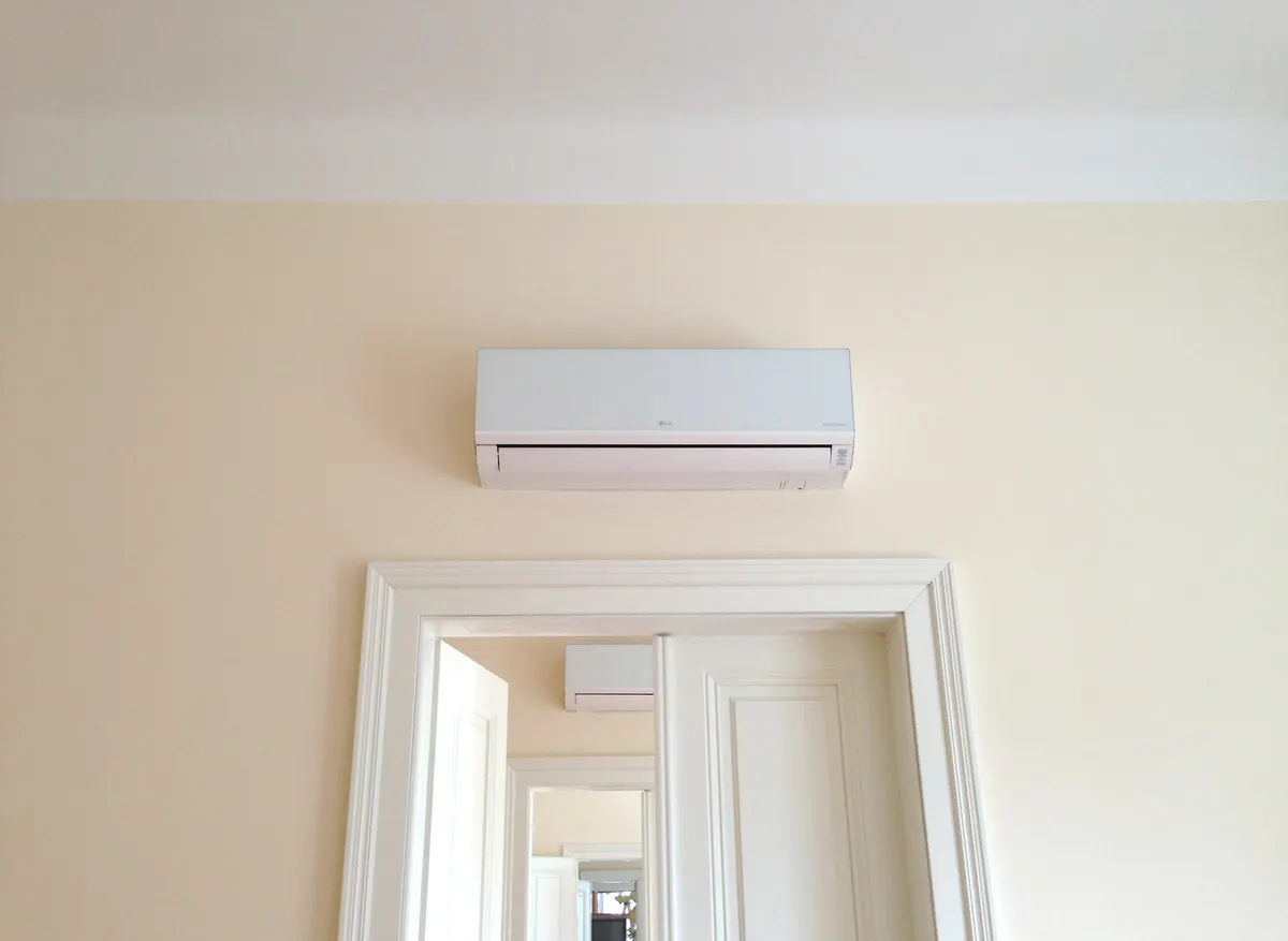 LG Wandgerät über einer Altbau-Tür, Leitungen unter Putz